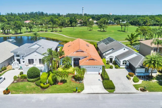 an aerial view of city and lake with trees all around