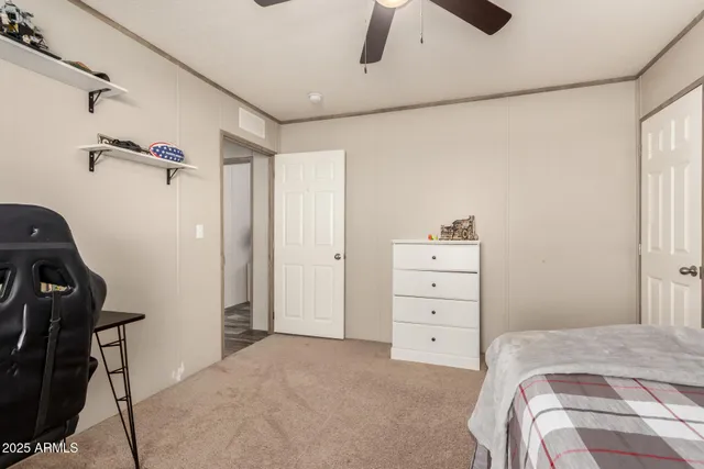 a view of a bedroom with natural light and hardwood floor