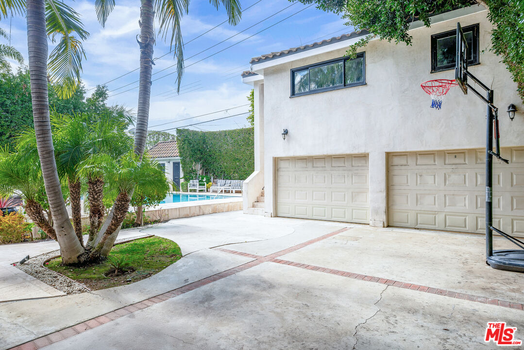 607 North Hillcrest Road Beverly Hills, CA 90210 - Photo 16 of 16 a front view of a house with garden