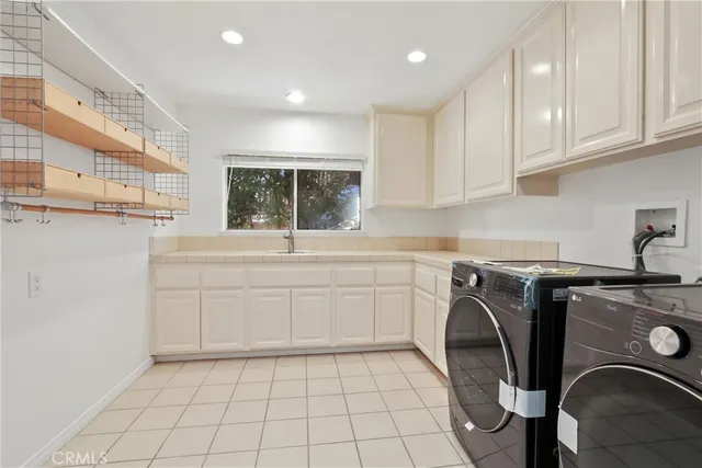a utility room with cabinets washer and dryer