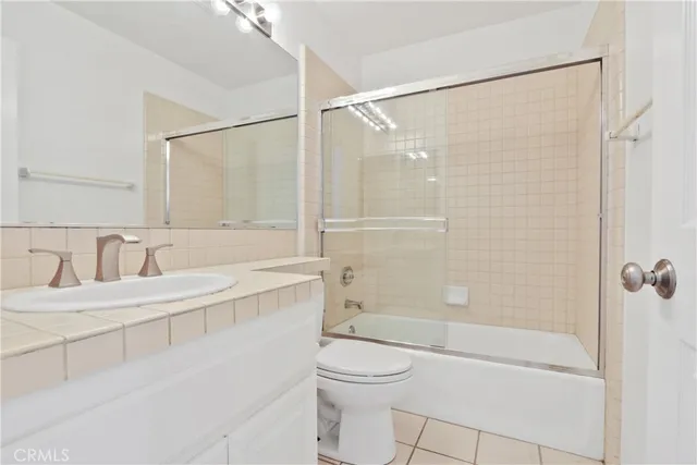 a bathroom with a bathtub shower sink vanity and toilet