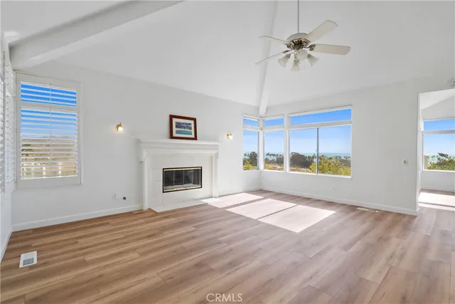 a view of an empty room with a fireplace and a window