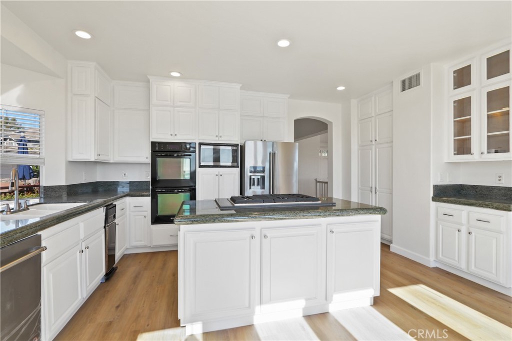 34152 Cambridge Road Dana Point, CA 92629 - Photo 8 of 25 a large kitchen with stainless steel appliances kitchen island granite countertop a sink and cabinets