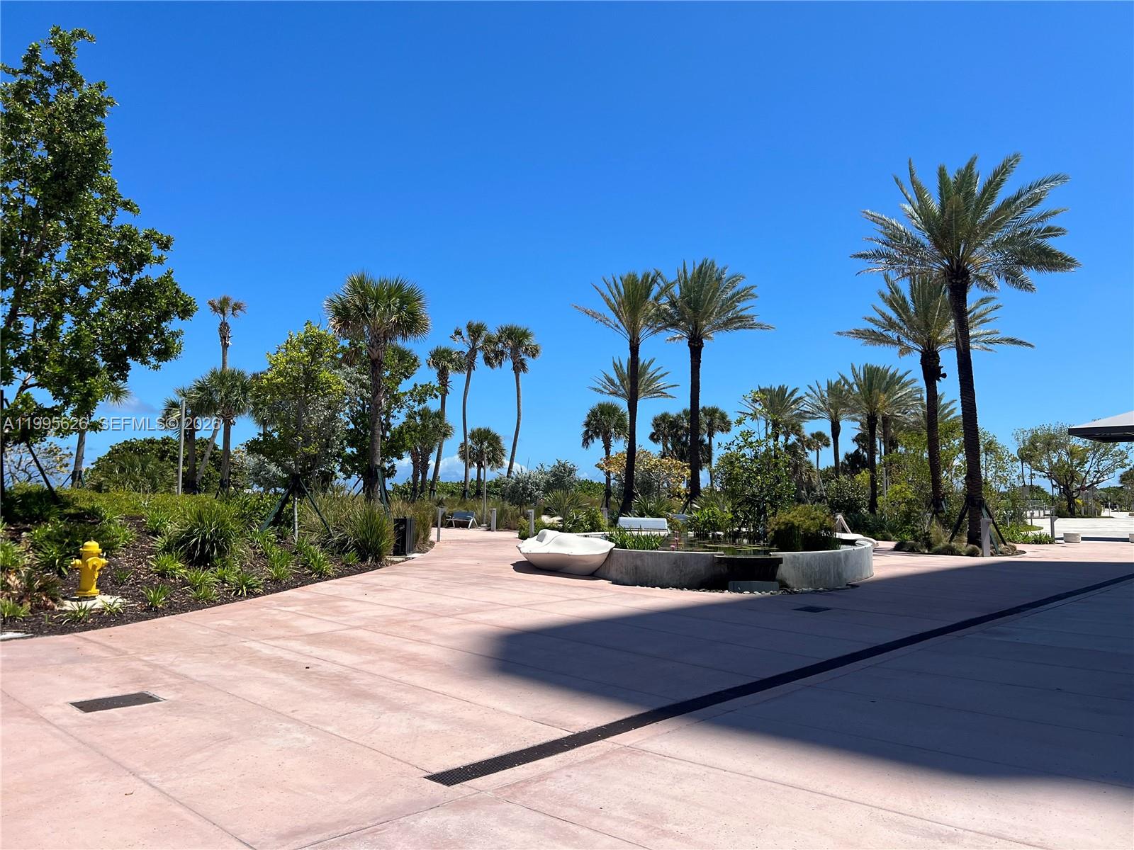 330 74th Street, Unit 5 Miami Beach, FL 33141 - Photo 18 of 19 a view of a terrace with a garden and palm trees