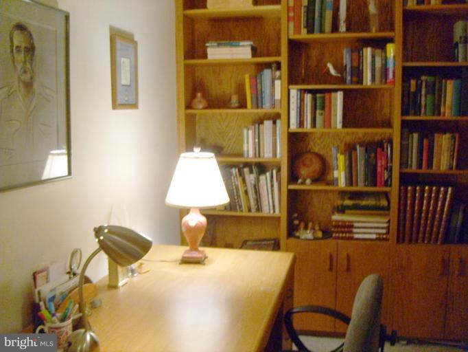 1001 26th Street Northwest, Unit 804 Washington, DC 20037 - Photo 5 of 7 a room with bookshelf and a chair