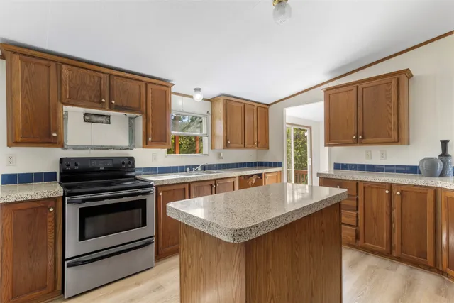 a kitchen with stainless steel appliances granite countertop a refrigerator a stove a sink and a microwave