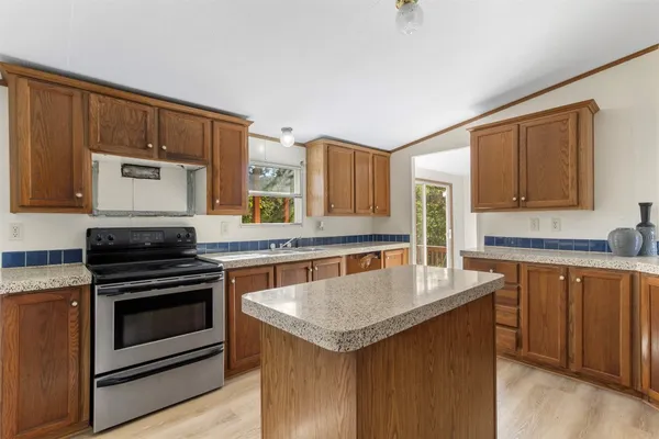 a kitchen with stainless steel appliances granite countertop a refrigerator a stove a sink and a microwave