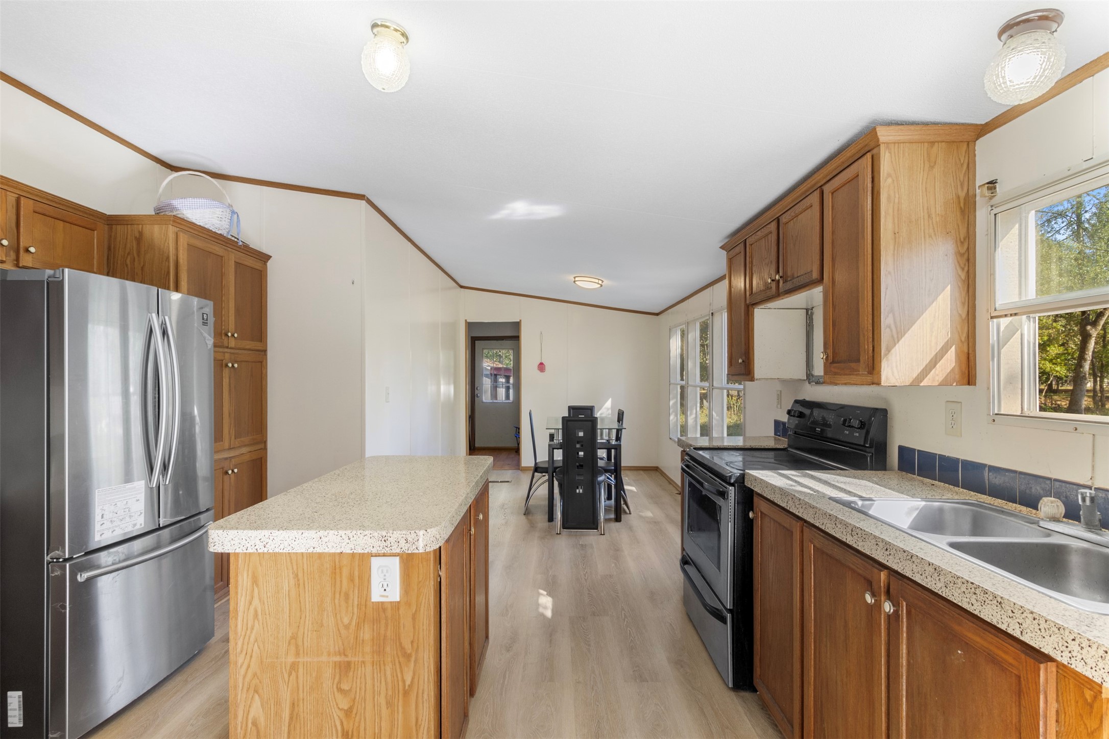 27182 East River Road Splendora, TX 77372 - Photo 25 of 40 a kitchen with stainless steel appliances granite countertop a refrigerator a stove a sink a dining table and chairs with wooden floor