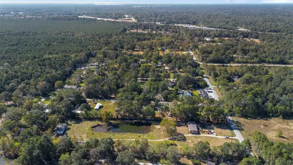an aerial view of house with yard and mountain view in back