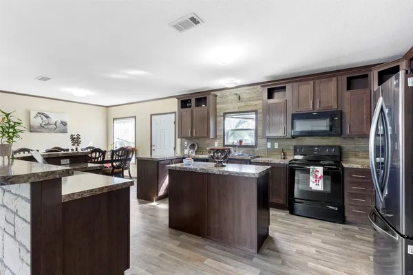 a kitchen with stainless steel appliances granite countertop sink stove top oven and refrigerator