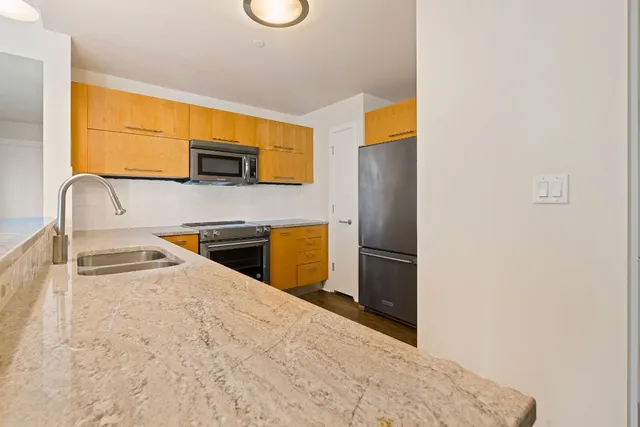 a kitchen with stainless steel appliances granite countertop a sink and a microwave