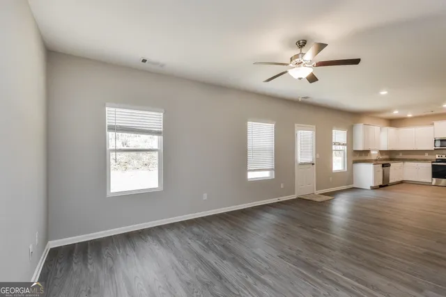 a view of an empty room with a chandelier fan