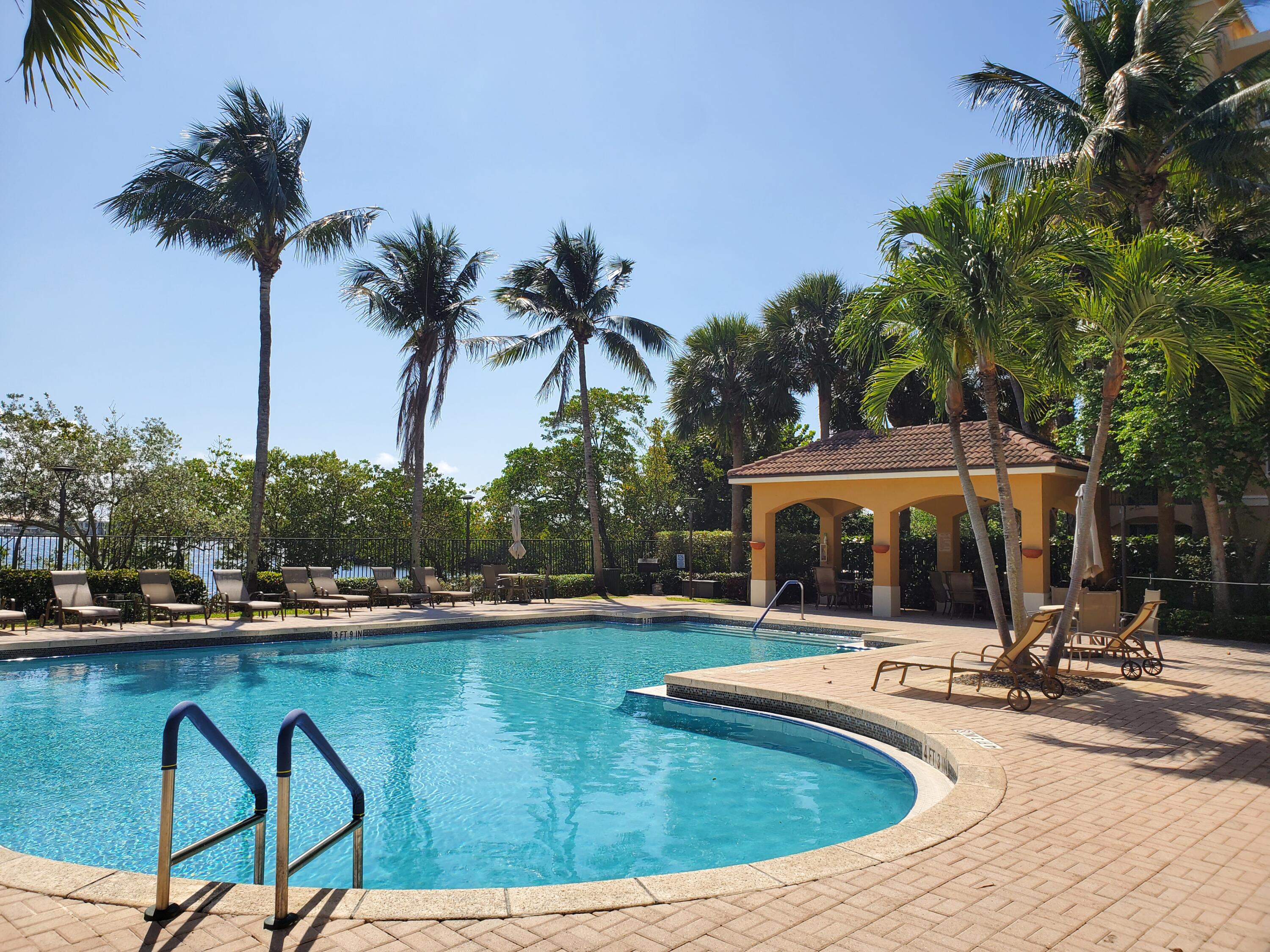 1000 Scotia Drive, Unit 106 Hypoluxo, FL 33462 - Photo 17 of 28 a view of a swimming pool with a patio and a yard