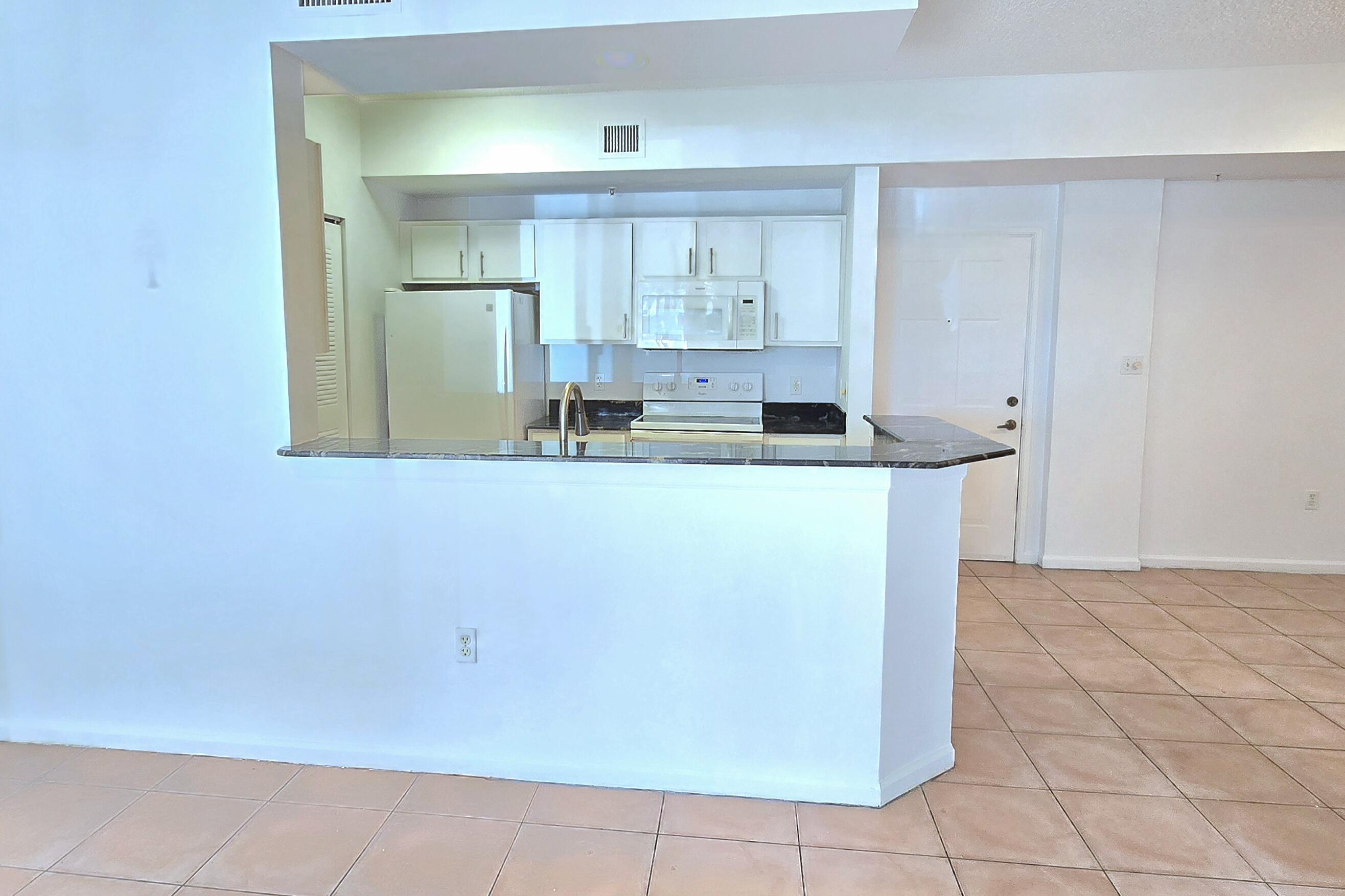 1000 Scotia Drive, Unit 106 Hypoluxo, FL 33462 - Photo 6 of 28 a room with kitchen island a sink a stove and cabinets