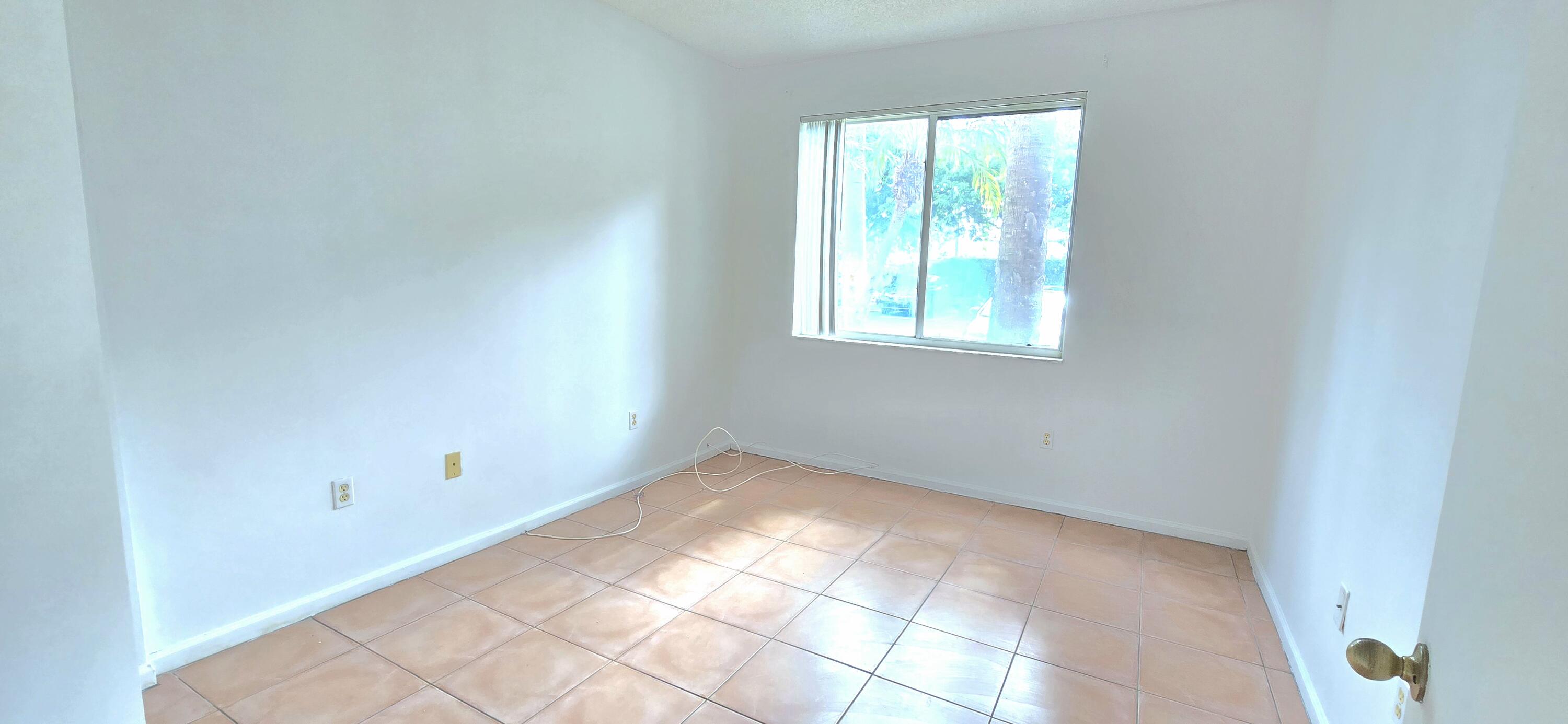 1000 Scotia Drive, Unit 106 Hypoluxo, FL 33462 - Photo 9 of 28 an empty room with windows