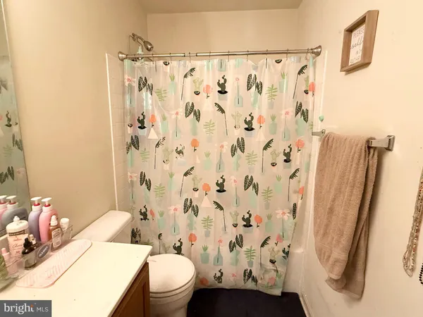 a white toilet sitting next to a bathroom sink and a shower