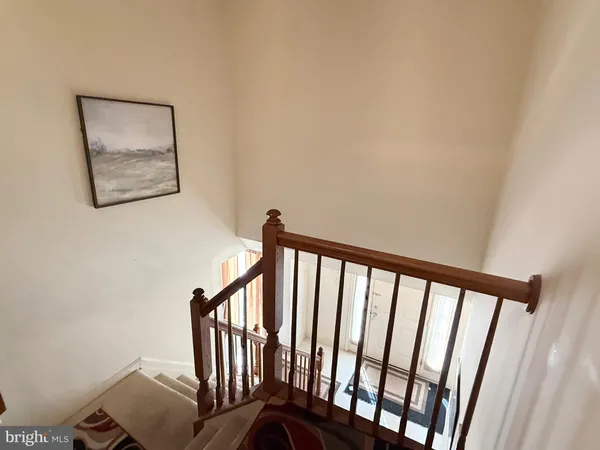a view of staircase with railing and white walls