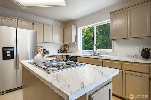 a kitchen with a stove a sink a refrigerator and cabinets