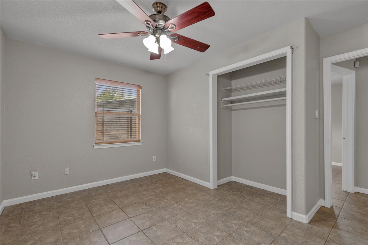 7604 Robalo Road Austin, TX 78757 - Photo 22 of 36 An inviting room features a practical ceiling fan, a window for natural illumination, and easy-care tile flooring.