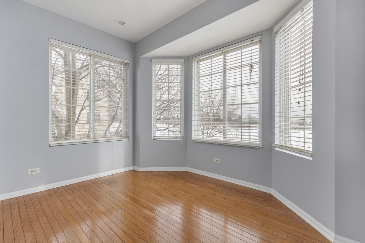 3185 Ketch Court Aurora, IL 60503 - Photo 13 of 25 a view of an empty room with wooden floor and a window