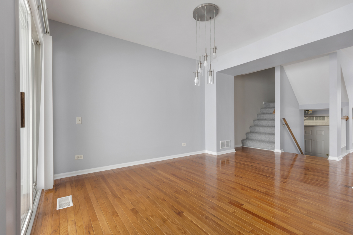 3185 Ketch Court Aurora, IL 60503 - Photo 7 of 25 a view of an empty room with wooden floor and stairs