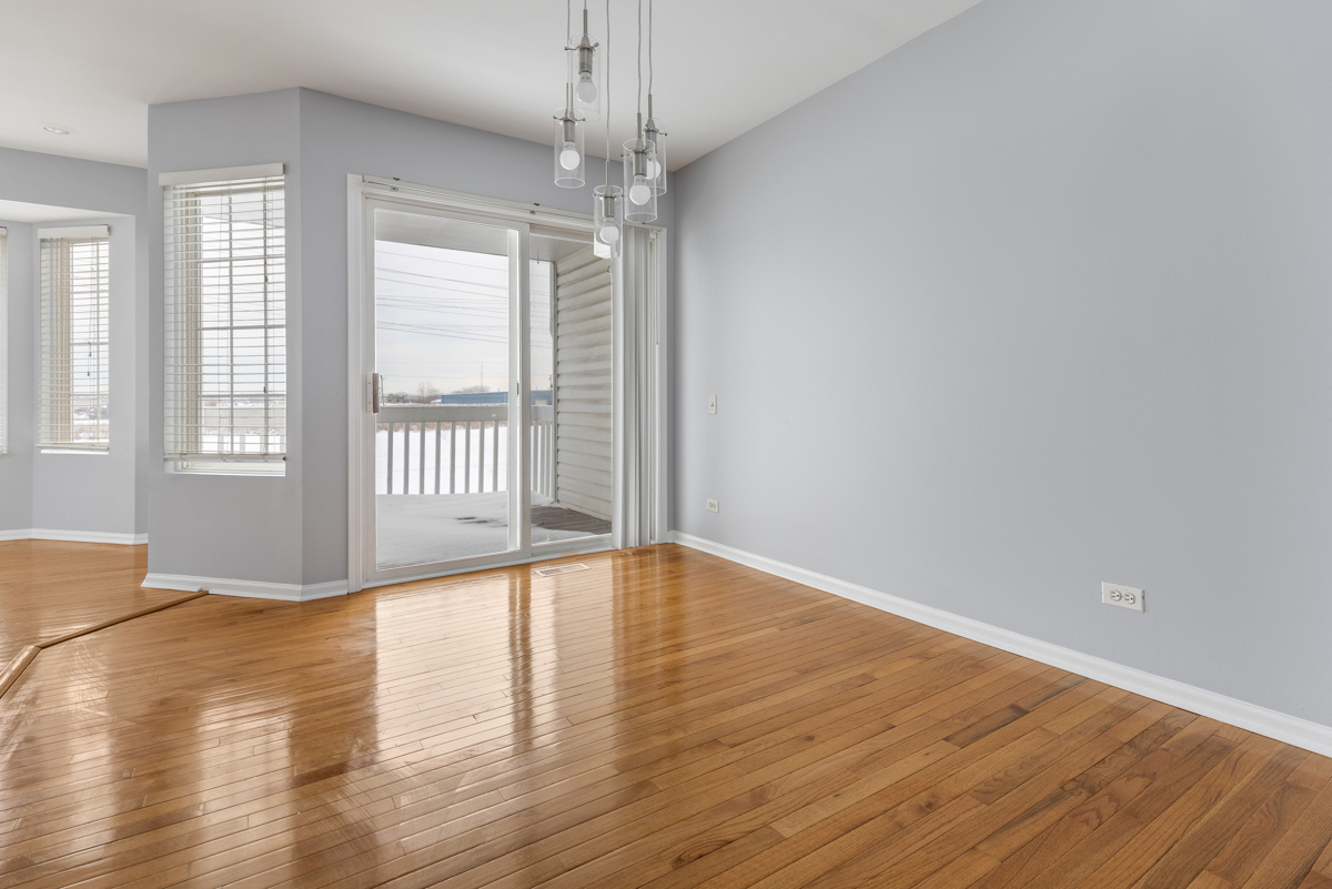 3185 Ketch Court Aurora, IL 60503 - Photo 8 of 25 a view of an empty room with wooden floor and a window