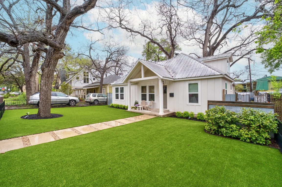 a front view of a house with a garden and trees