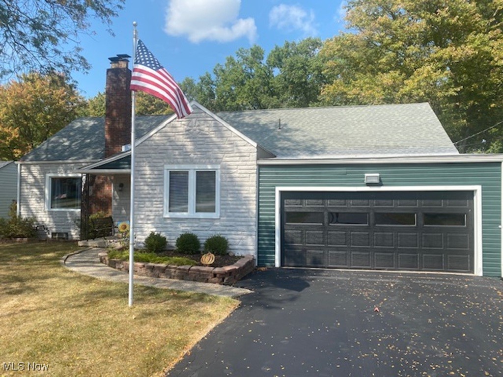 4270 Mellinger Road Canfield, OH 44406 - Photo 45 of 49 View of front of house with a chimney, driveway, a garage, a front lawn, and a shingled roof