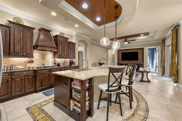 a kitchen with stainless steel appliances granite countertop a stove a sink dishwasher a dining table and chairs with wooden floor