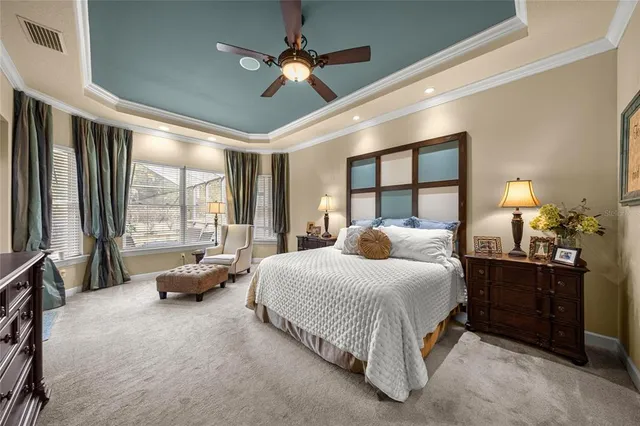 a bedroom with a bed couch and large window