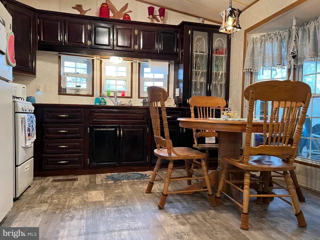 a kitchen with stainless steel appliances granite countertop a stove a refrigerator a sink dishwasher with a dining table and chairs