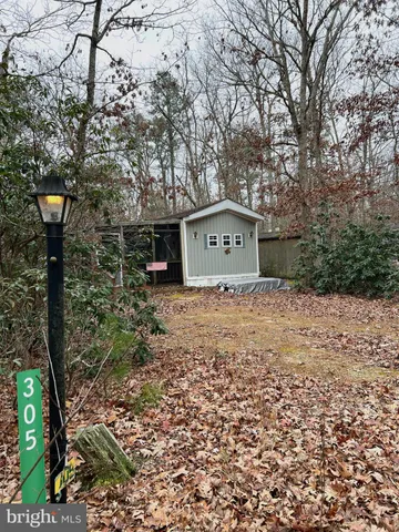 a wooden house with trees in the background