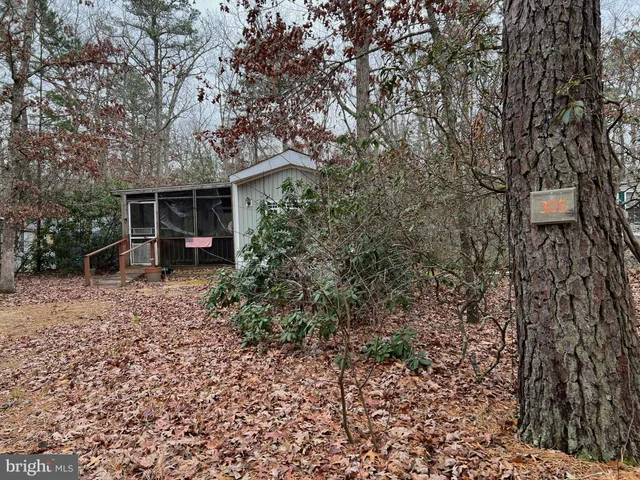 a view of empty room with wooden floor and windows