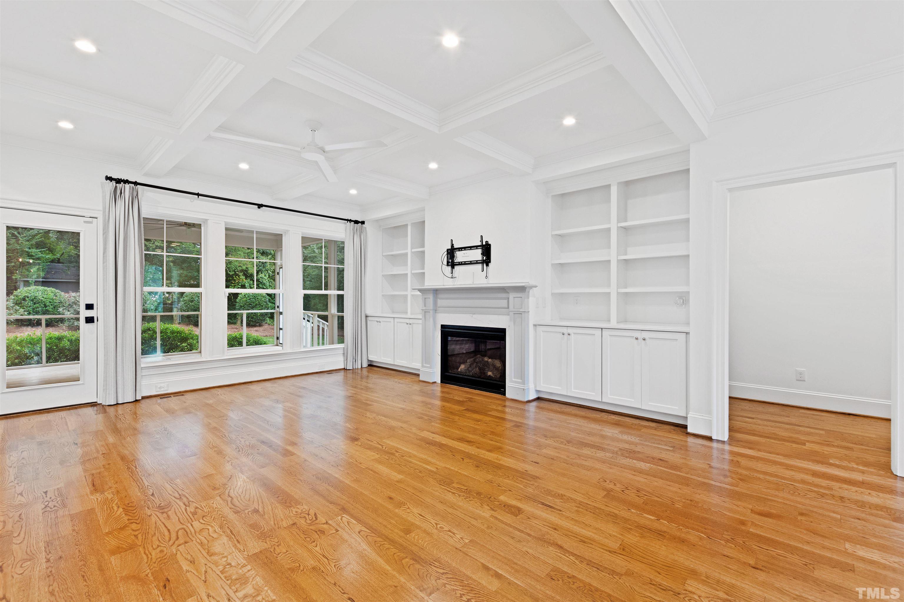 401 Latimer Road Raleigh, NC 27609 - Photo 11 of 45 an empty room with wooden floor fireplace and windows