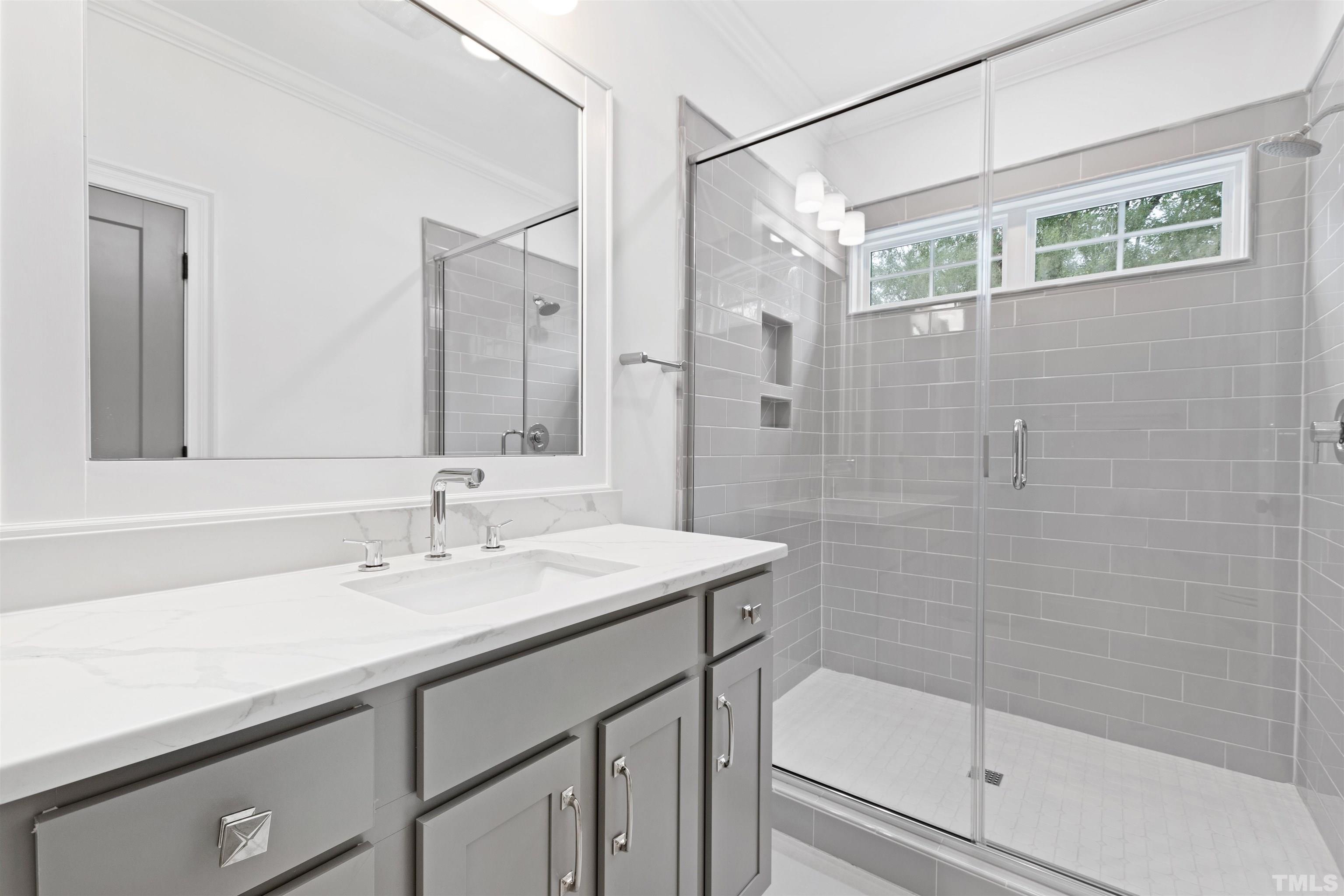 401 Latimer Road Raleigh, NC 27609 - Photo 16 of 45 a bathroom with a sink a mirror and a shower
