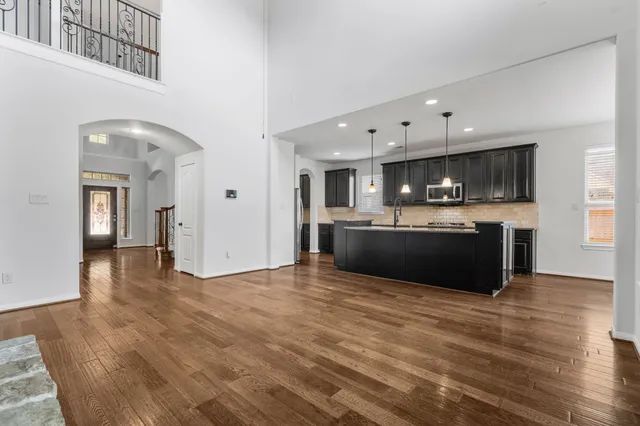 a view of kitchen with granite countertop a sink and a stove top oven