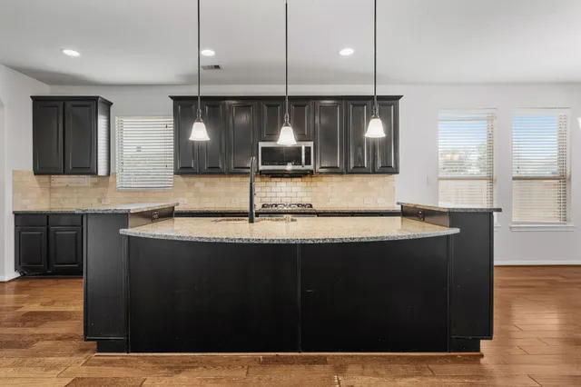 a kitchen with a sink a counter top space and cabinets
