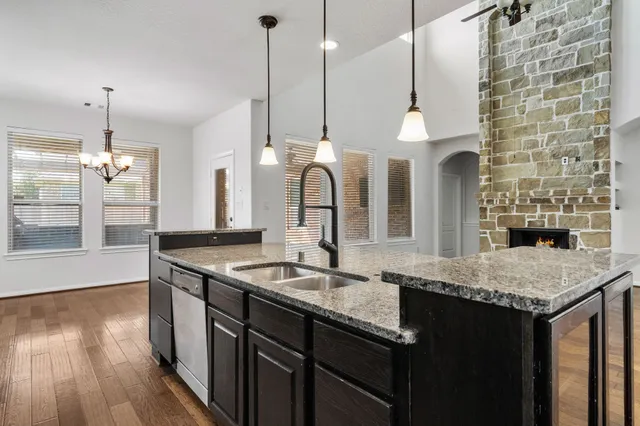 a kitchen with granite countertop a sink a counter space and wooden floor