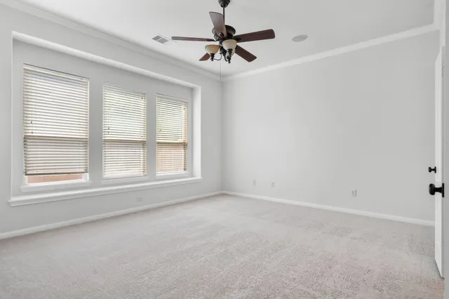 an empty room with fan and windows