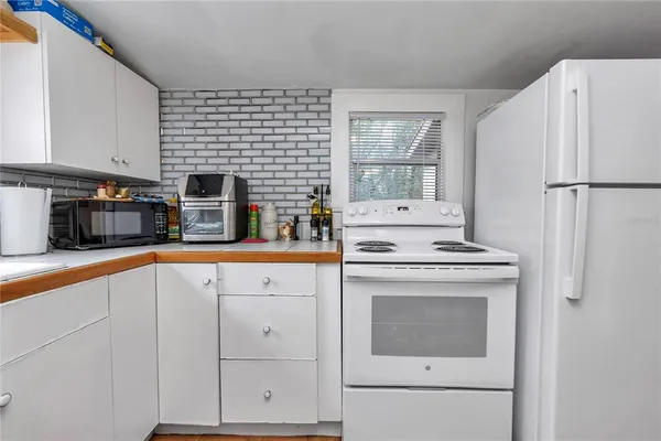 a kitchen with stainless steel appliances granite countertop a refrigerator a stove a sink a dining table and chairs