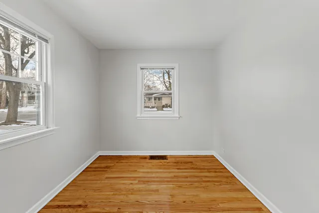 a view of empty room with wooden floor