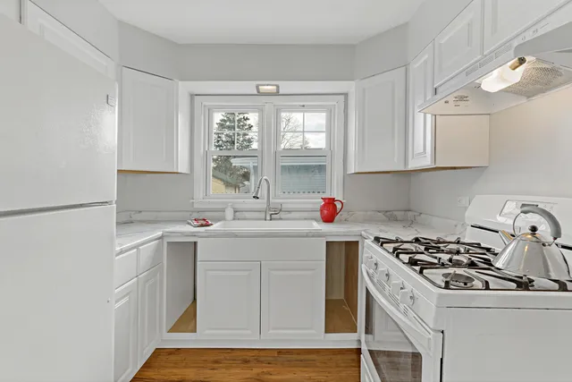 a kitchen with a sink a stove and cabinets