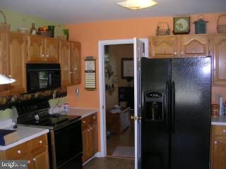 25022 Collins Wharf Road Eden, MD 21822 - Photo 5 of 10 a kitchen with granite countertop a stove and a refrigerator