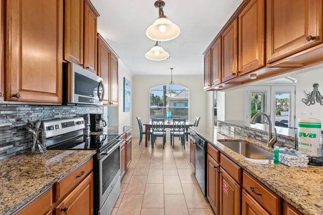 a large kitchen with granite countertop a large stove a sink a dining table and chairs