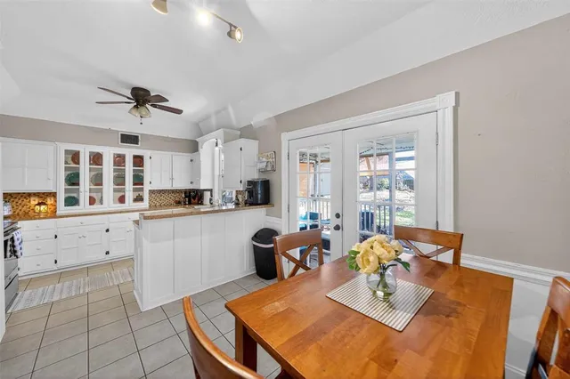 a kitchen with a dining table chairs and white appliances
