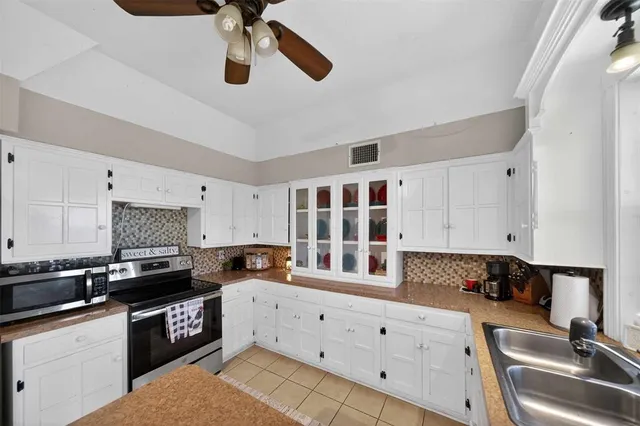a kitchen with granite countertop a sink stainless steel appliances and cabinets