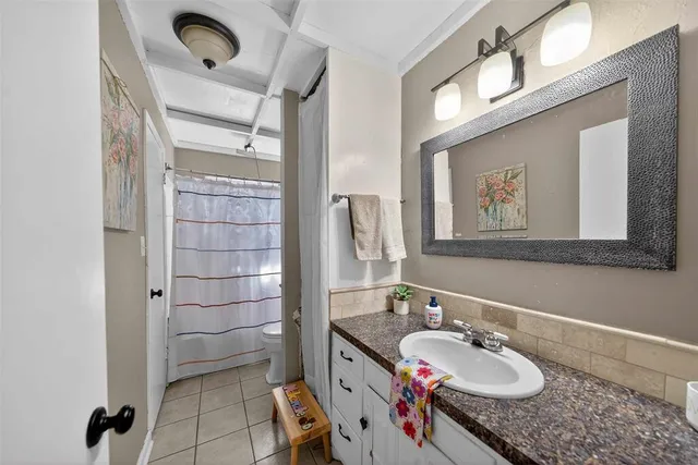 a bathroom with a granite countertop sink a mirror and shower