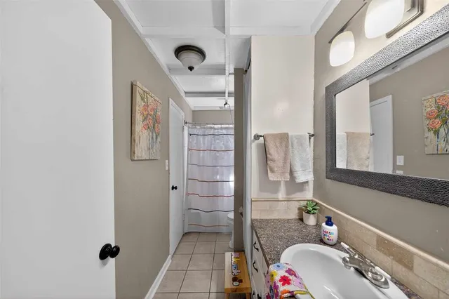 a bathroom with a granite countertop sink mirror vanity and toilet