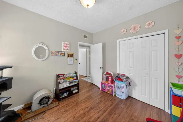 a bedroom with a bed and a wooden floor