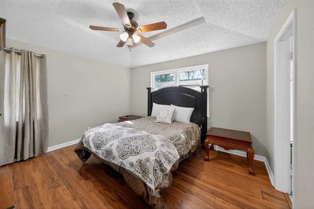 a bedroom with bed and wooden floor